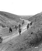 Soldiers marching through the Kasserine Pass