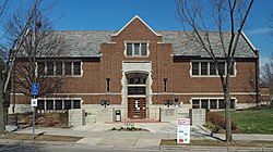 One-story brick building with raised basement and central entrance on a small plaza